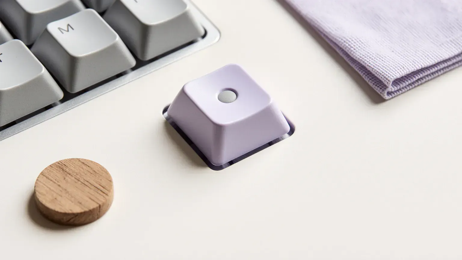 Macro still life of a keyboard key with a tactile dot and a violet key cap