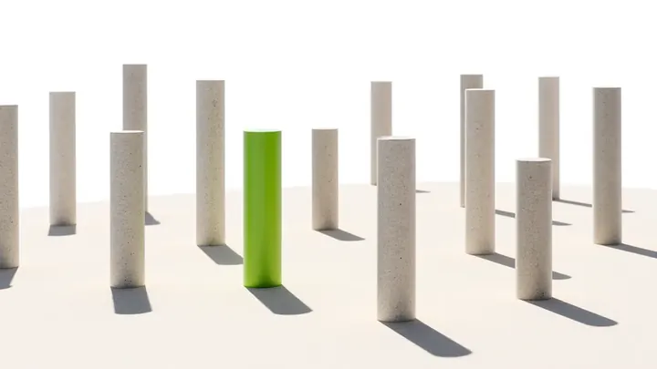 A field of stone columns of different heights with one lime column standing out, suggesting ad prices