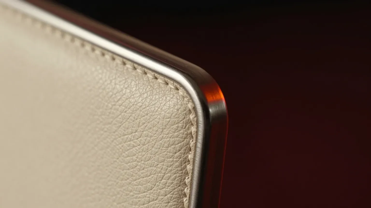Macro close-up of grained leather meeting a brushed-metal clasp