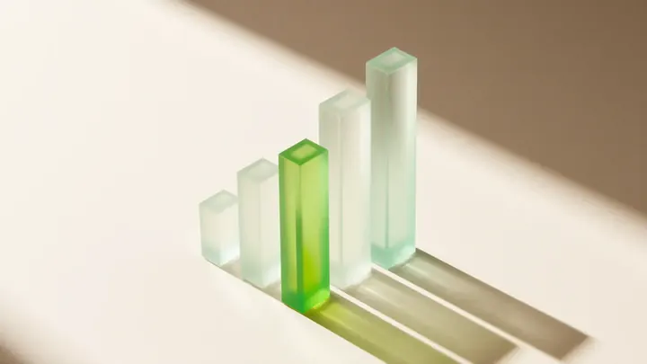 Four glass bars of rising height, the third one lime green, standing for four website price tiers
